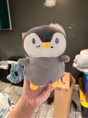 Gray Penguin Plush with Yellow Beak & Feet with a Donut and has a suction cup